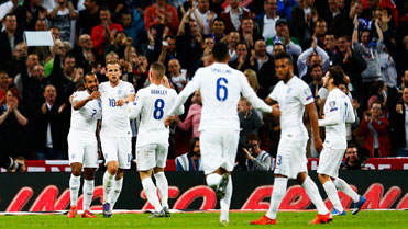 The England players celebrate Walcott's goal