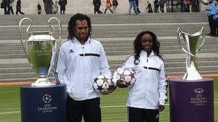 Christian Karembeu and Eniola Aluko with the UEFA Champions League and UEFA Women’s Champions League trophies
