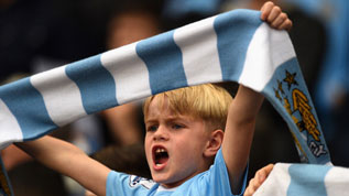 A Manchester City fan cheers on his team
